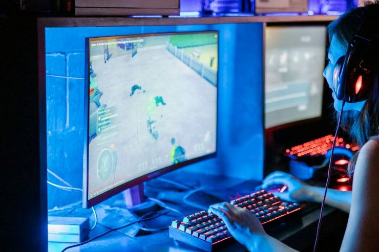 Una persona con cuffie gioca a un videogioco su un computer